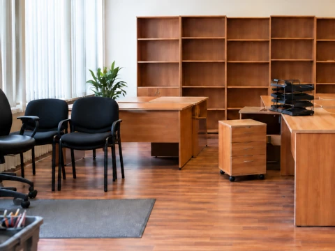 Wooden office desks, chairs and empty storage cabinets